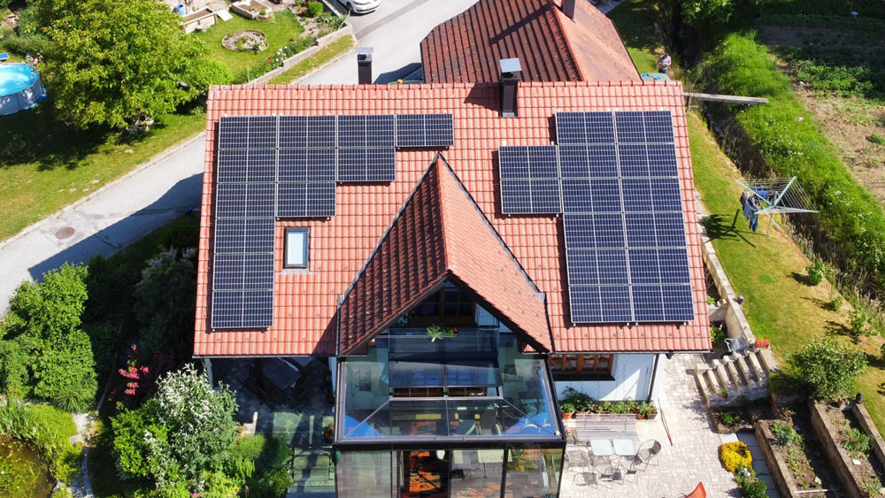 Photovoltaikanlage auf dem Dach eines Einfamilienhauses mit roten Dachziegeln
